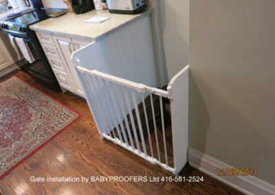 White baby gate installed where the stairs start past both walls.