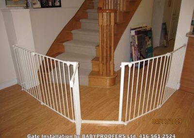 White baby gate installed around stairs and hallway.
