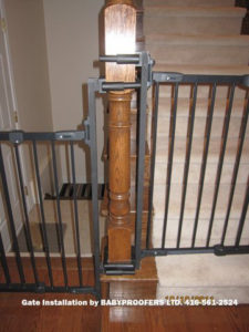 Details of mounting brackets for baby gate attached to newel post.