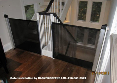 Black retractable baby gates installed on either side of stair openings.
