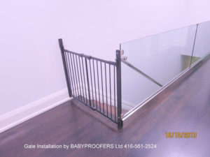 Baby gate installation between glass partition and wall.