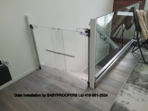 Crystal clear baby gate installed at the top of stairs.