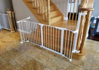 Baby gate and fence installed from newel post across wide stairs.